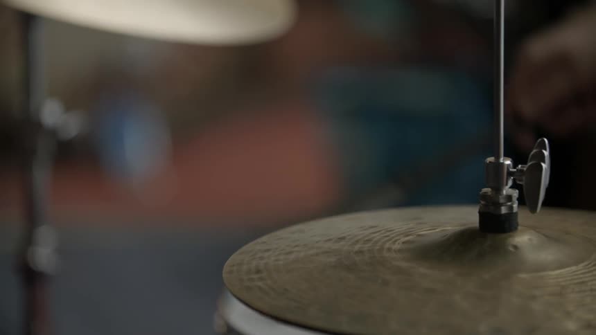 A drummer taps his symbol