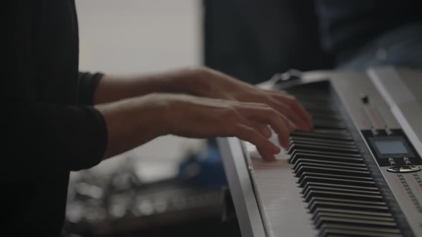 Hands playing an electronic piano