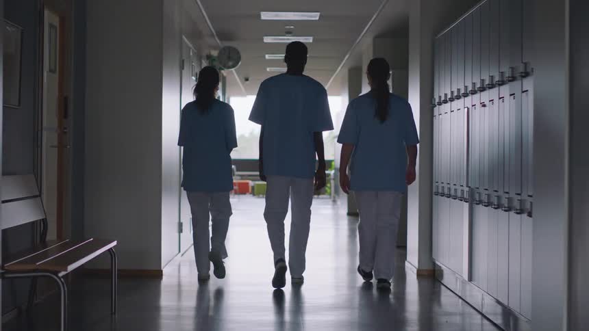 A group of medical staff walk down a hallway