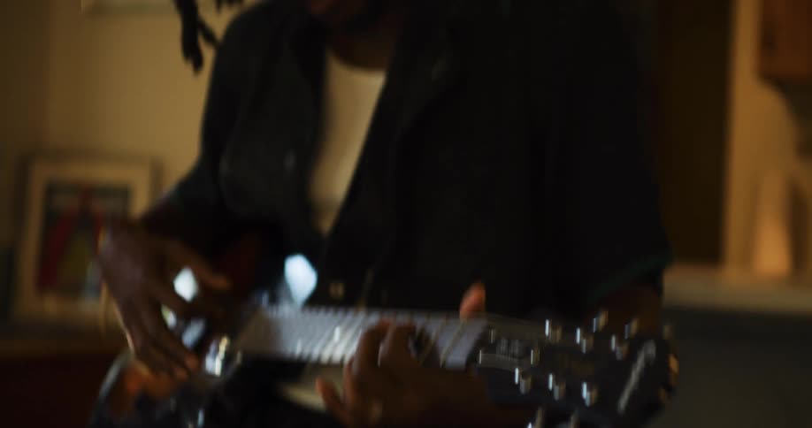 A man sitting playing a guitar