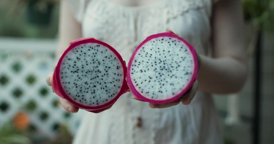 A woman opens a dragon fruit