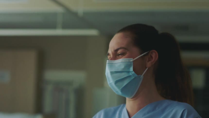 A nurse inside a hospital laughs