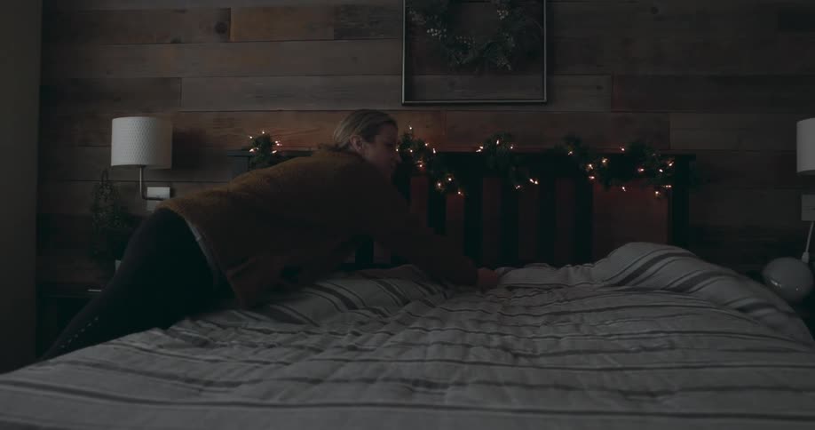 A woman making a bed at home