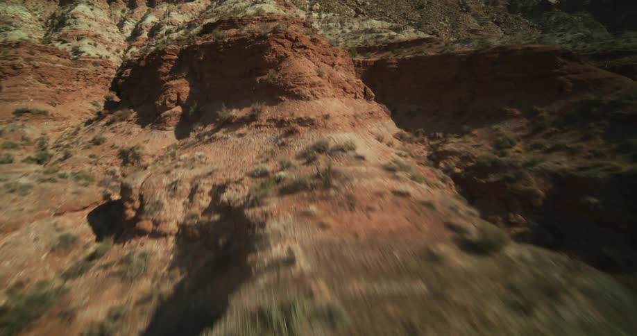 Bushes dot the slopes and sides of a canyon