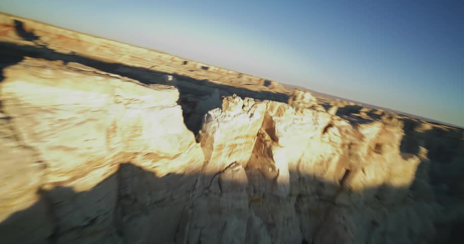The sun shines on rock formations and mesa in the badlands