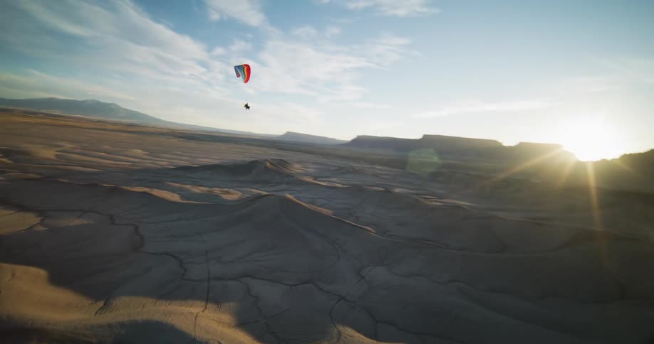 An aerial view of a person paragliding over a desert