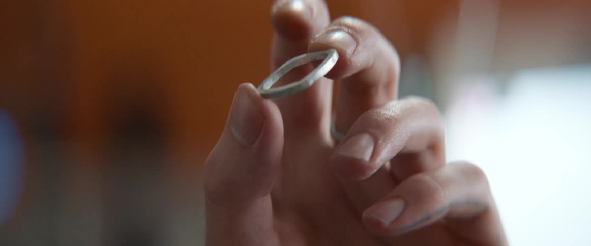 Person closely examines small metal square frames
