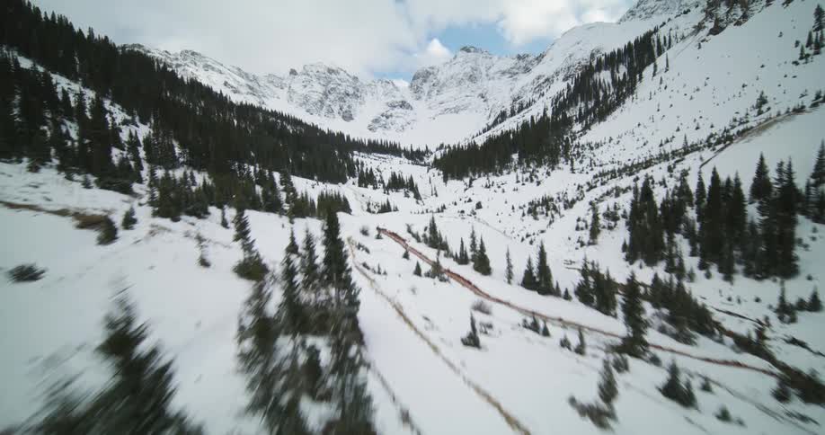 Camera flies over the snow covered mountains