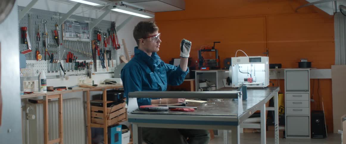 A man works in a garage shop with tools