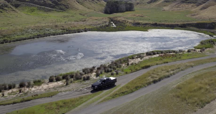 A pickup truck driving near a river