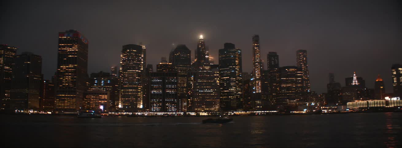 A boat is moving on the water near an urban city
