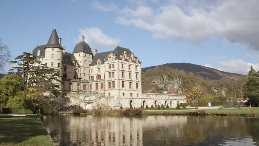People move around large manor backed by mountain