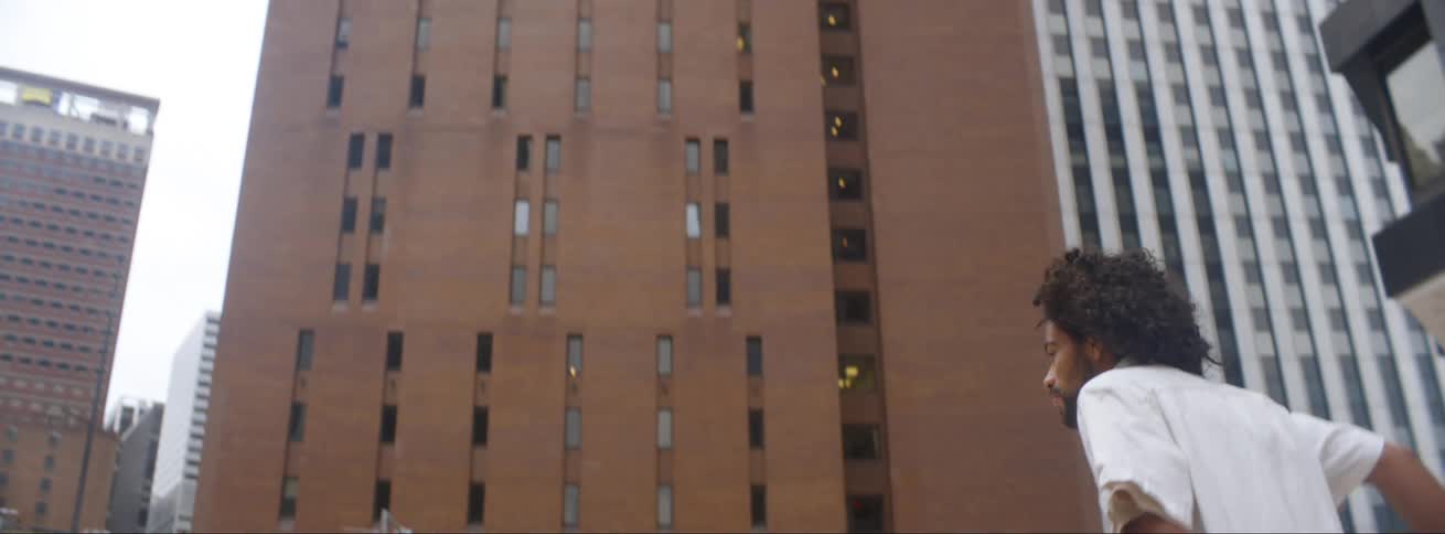 Young man pushes and rides a skateboard on a plaza in the city downtown