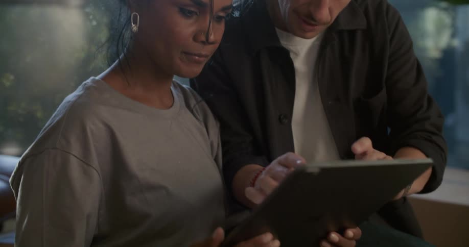 Two people looking at items on a tablet