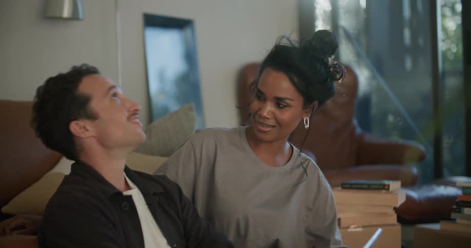 A man uses a tablet while talking with a woman