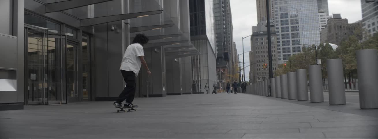 A person is skateboarding through a downtown city