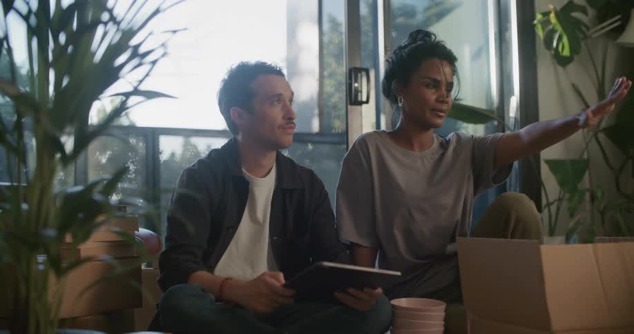A man and woman talk while looking at a tablet