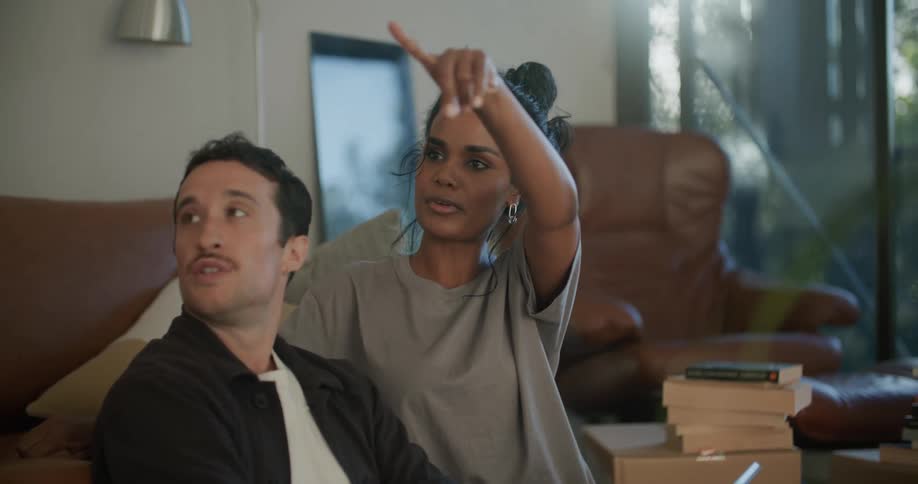 A man and woman talk on the couch