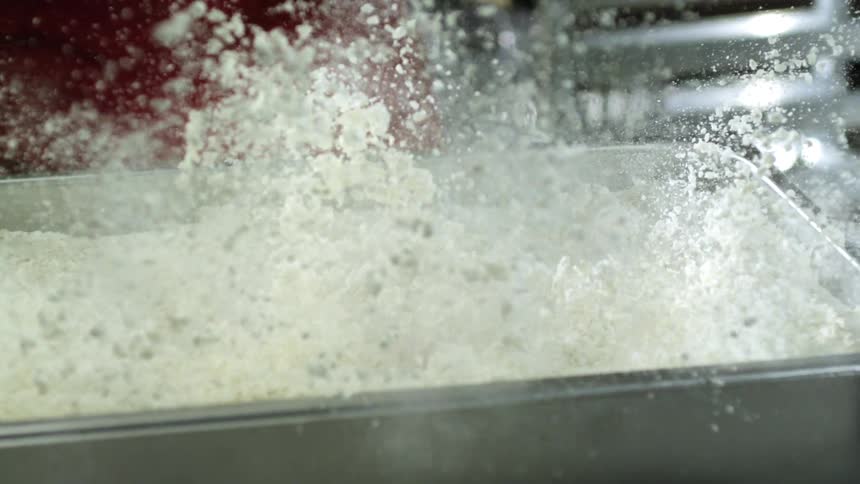 Chicken is dropped into the flour