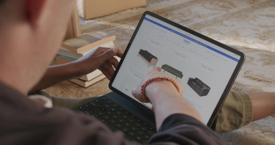 Man and woman sits shopping on laptop for a sofa