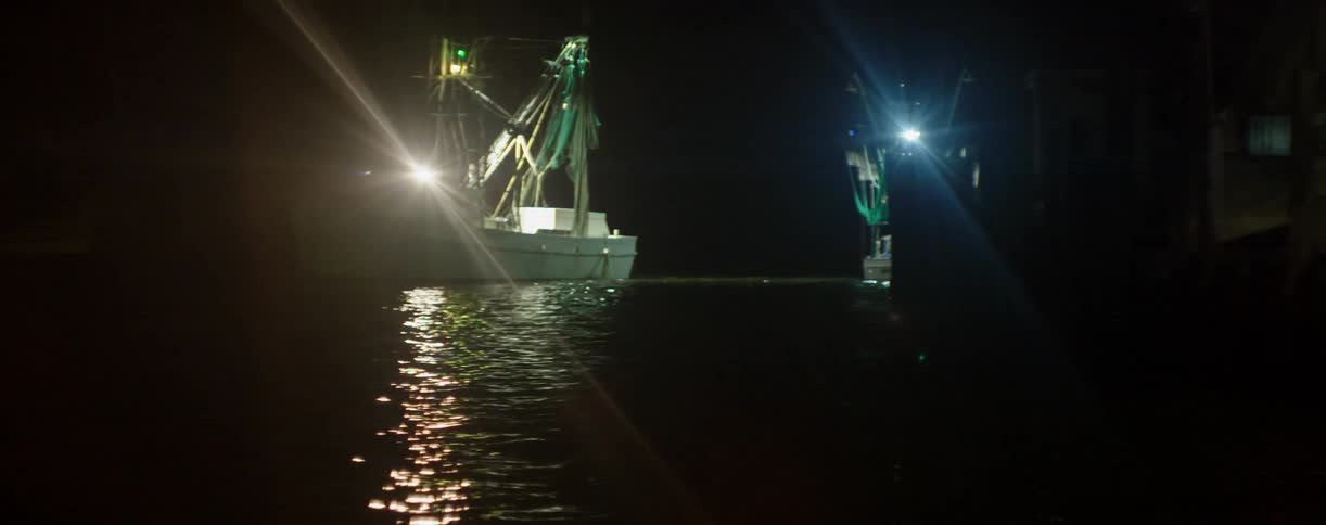 Fishing boats with lights ablaze at night