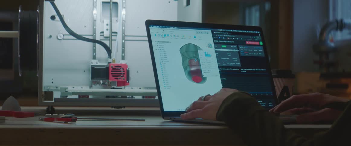 A man opens his laptop and begins working in a lab