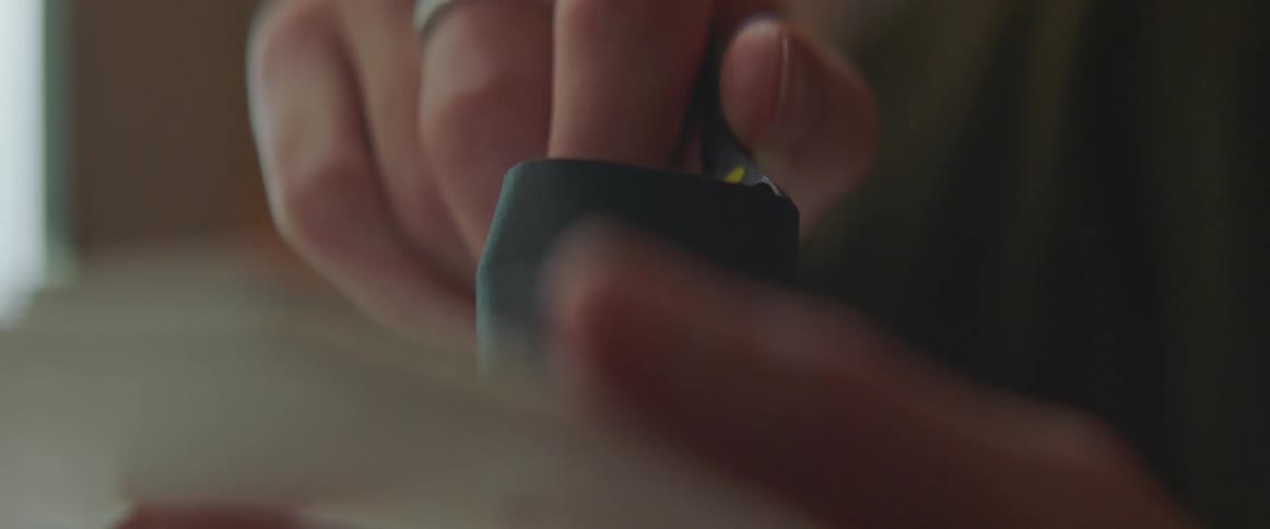 A man uses tweezers to trim a small cup like structure