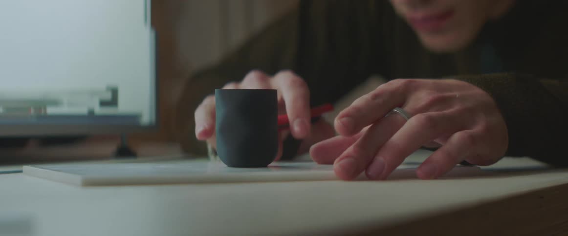 A man is using different crafting mediums as he sits at a table