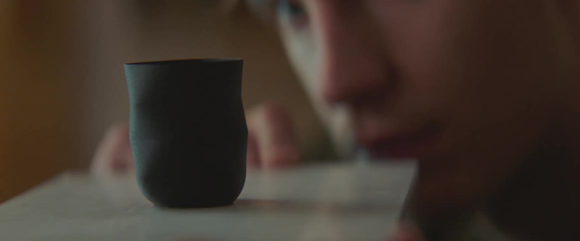 A man is balancing a cup on a tray indoors