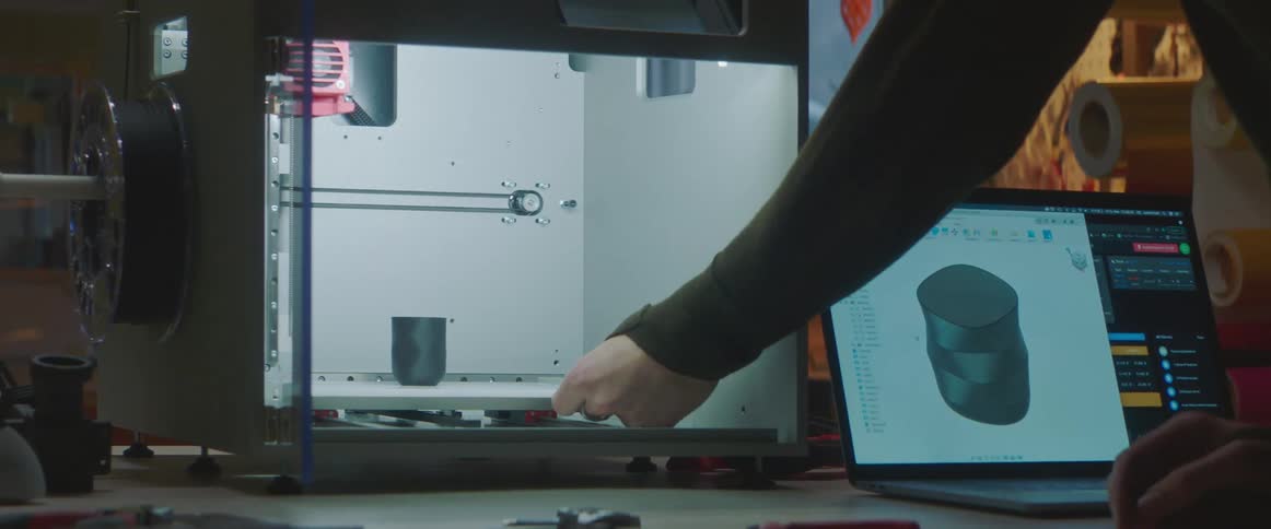 A person removes an object from the 3d printer