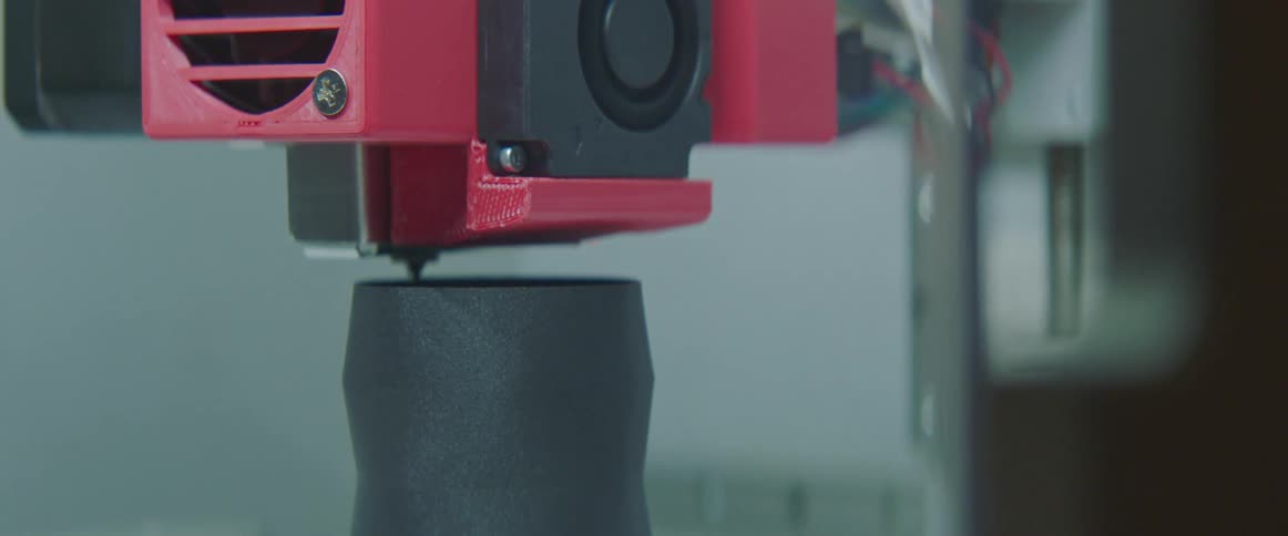 A black vase is created with a three dimensional printer