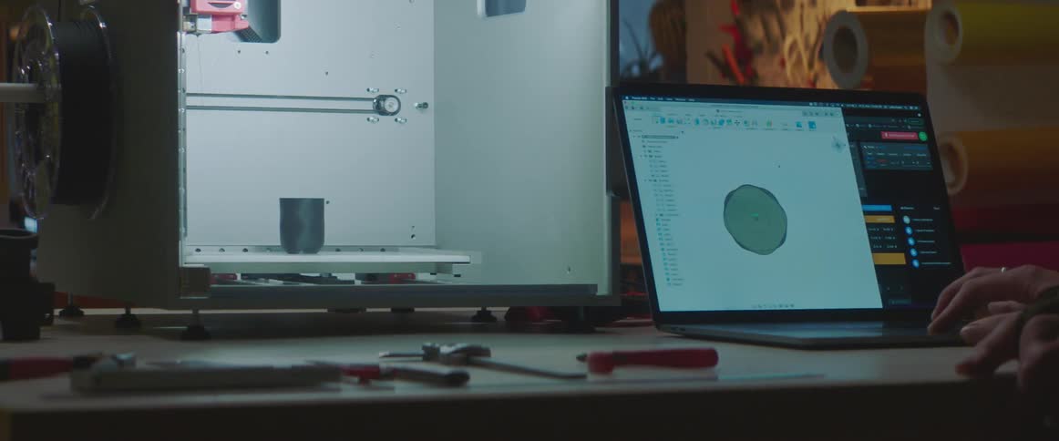 An engineer using software to design an object on a laptop