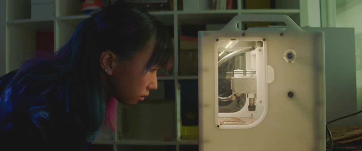 Woman leans over watching 3d printer