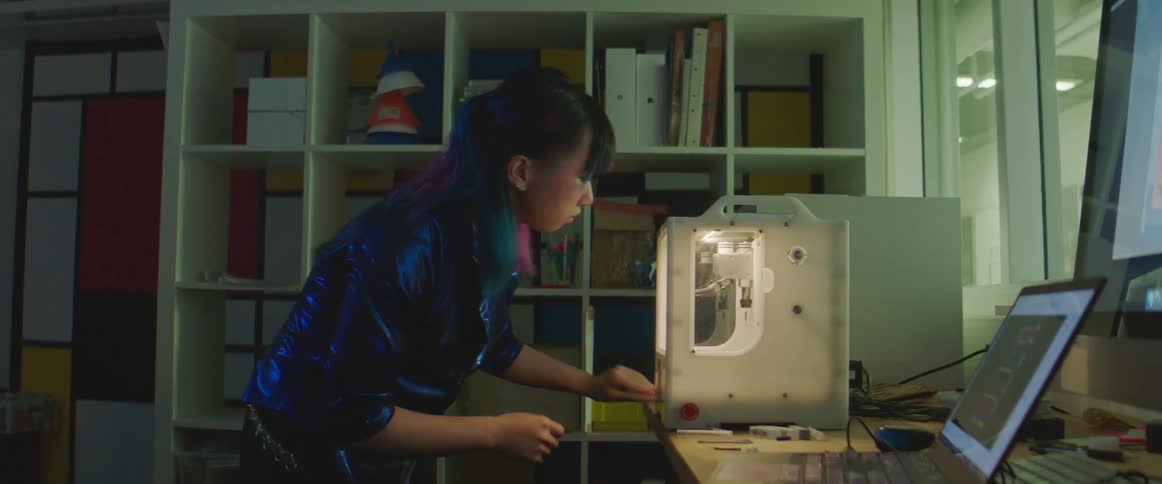 A woman is working on a 3d printer