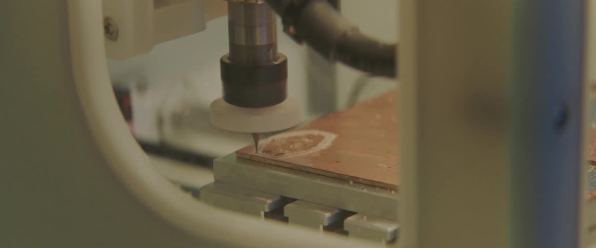 A piece of machinery etching wood in a factory setting