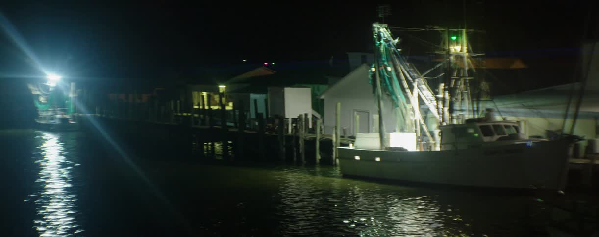 A dock has houses and a boat near the water