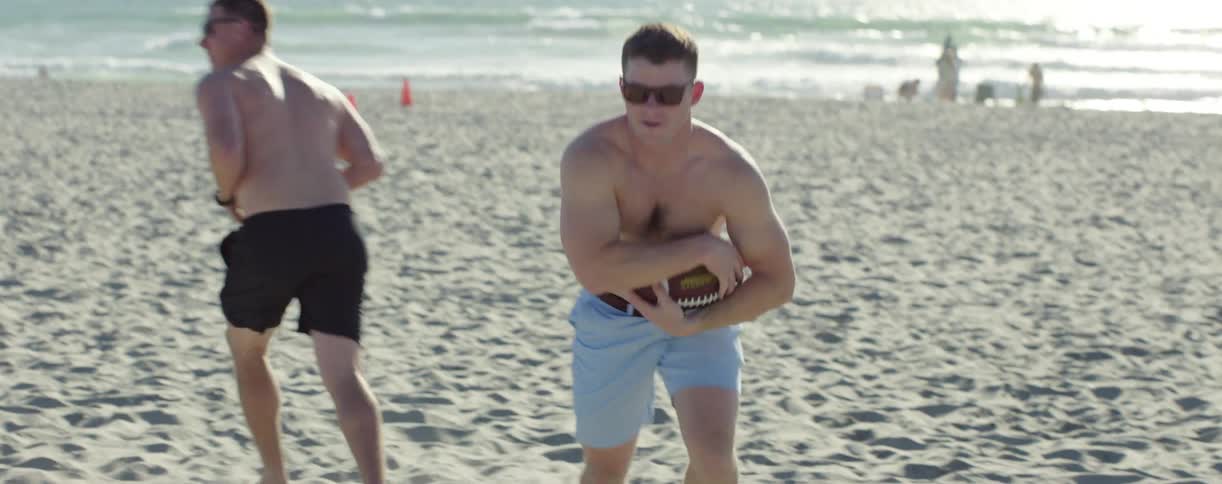 Men are playing football on the beach