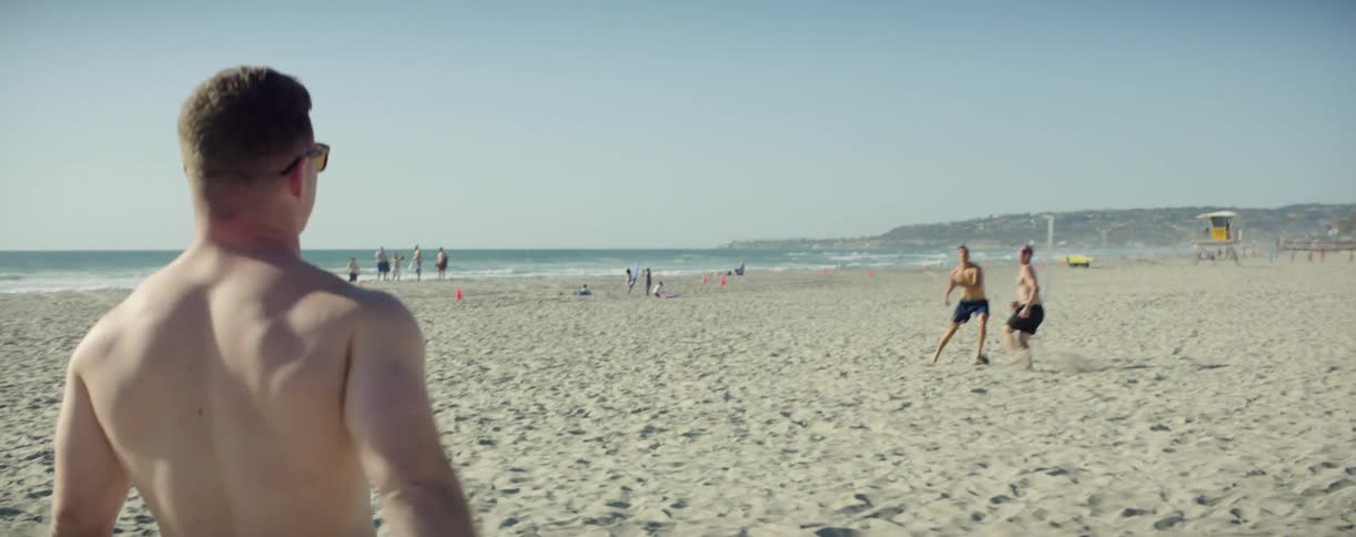 Men are playing football on the beach