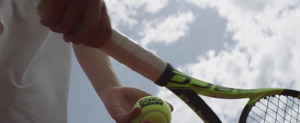 A tennis player gets ready to serve the ball