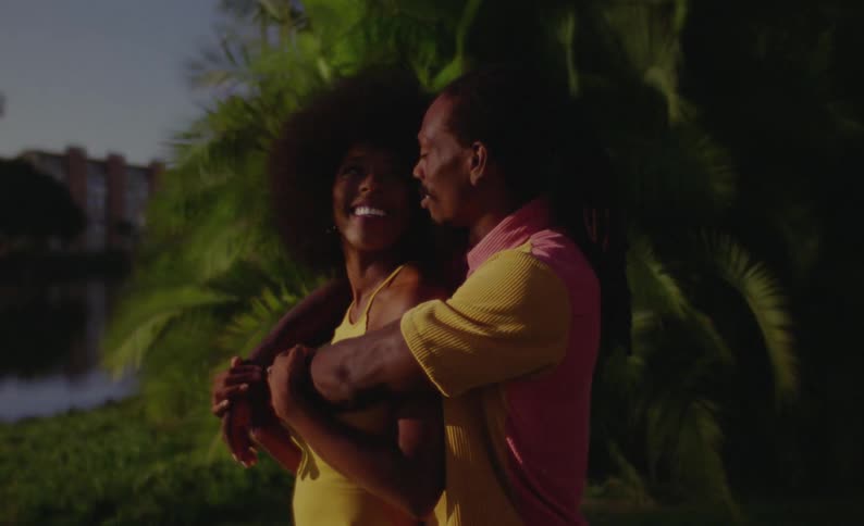 A woman turns her head and smiles at her boyfriend while they pose for photos