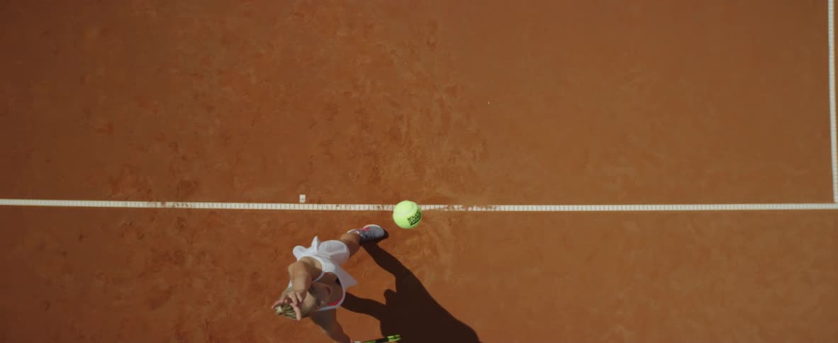 A tennis player throws up a ball and serves