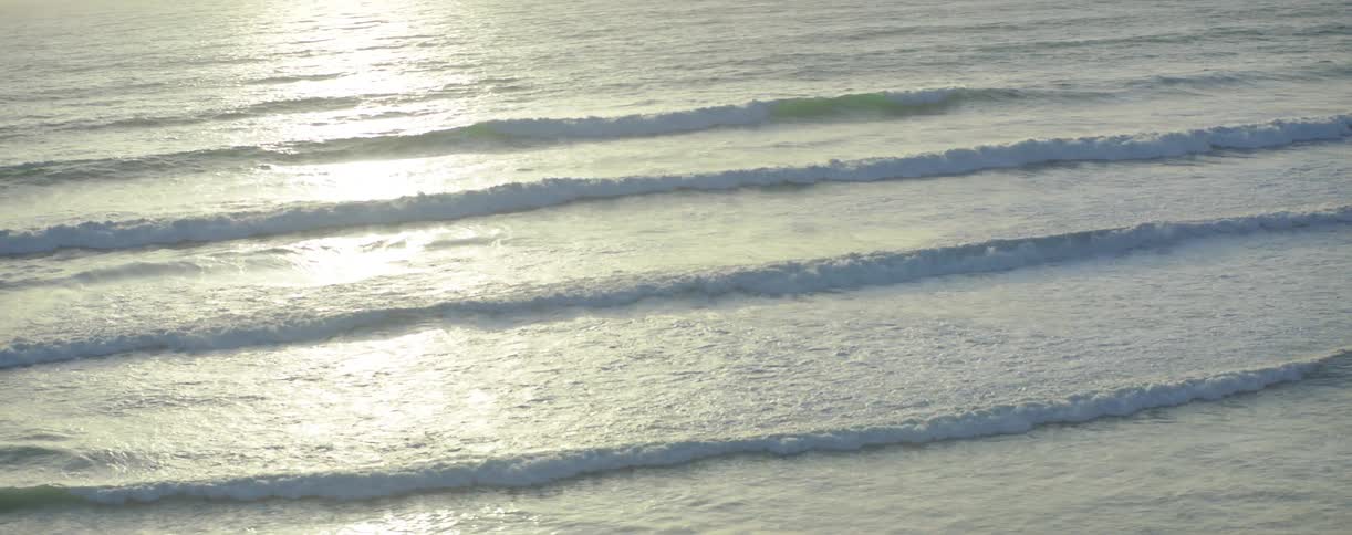 Waves slowly hit the shore at sunset