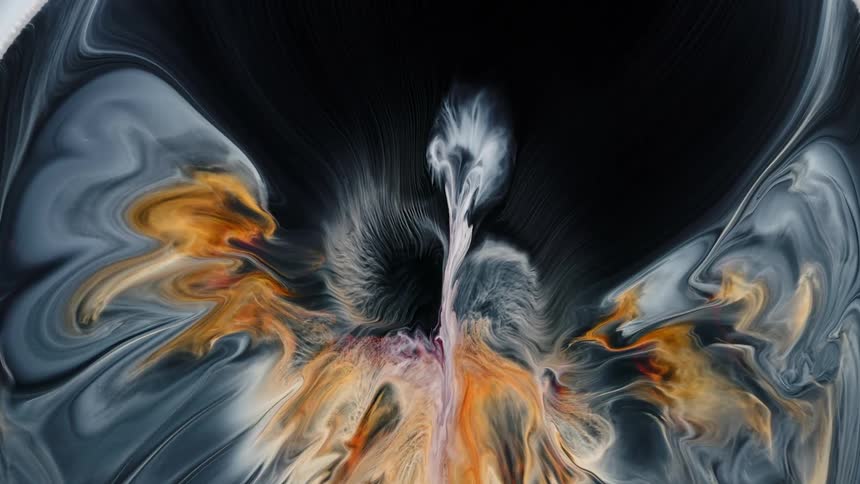 White and orange paints explode against a black background