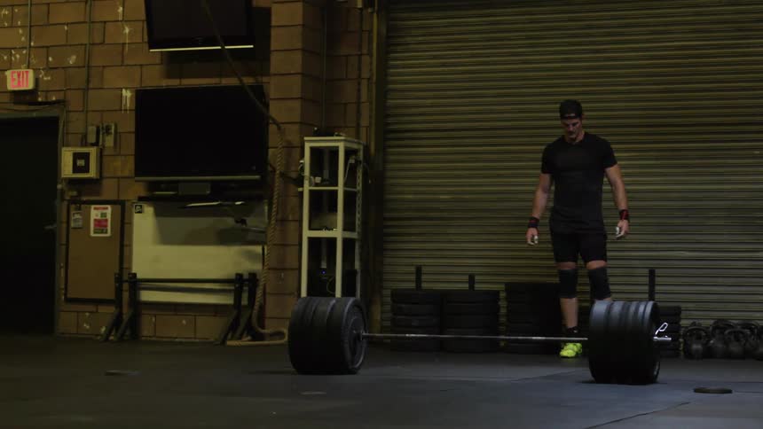 A man is dead lifting heavy weights