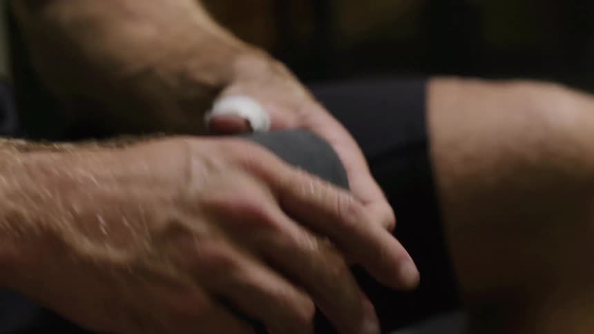 A man is winding some black tape in his hands