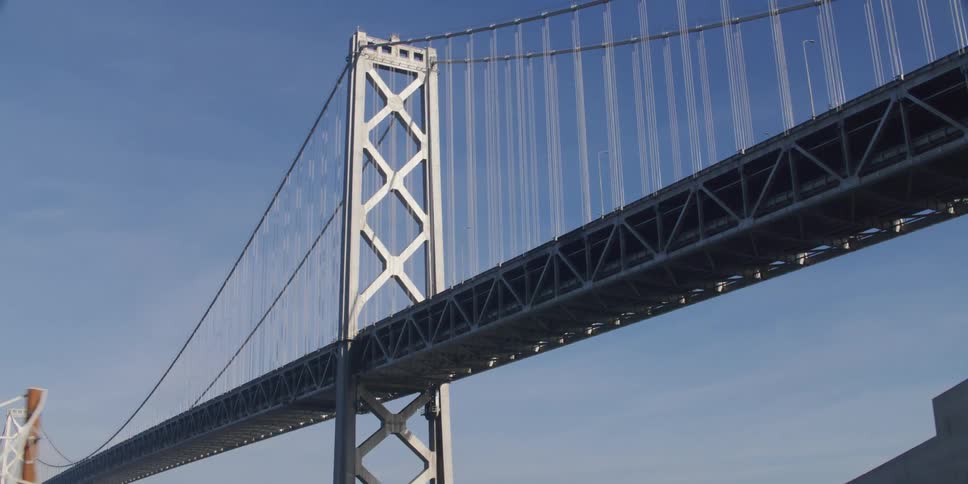 Suspension bridge with suspension cables on vertical suspenders seen from a moving car