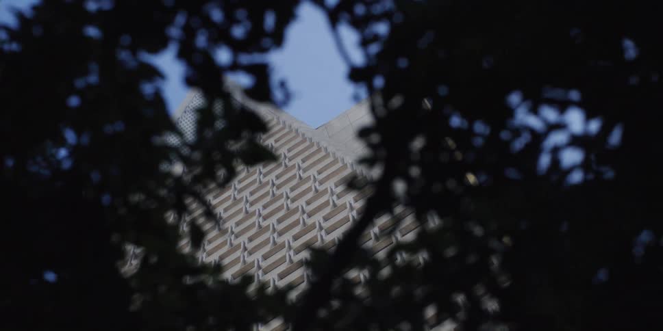 A view of a tall building in a city is displayed
