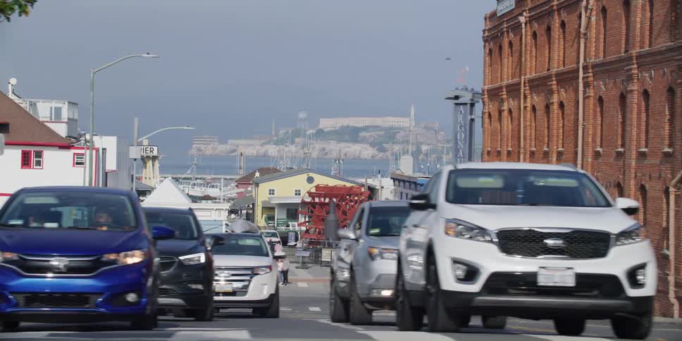 Cars are driving in traffic in a downtown city