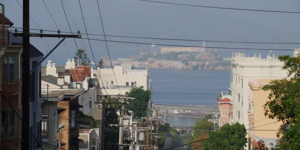 Apartment buildings and homes line the slope of a hill leading to the ocean