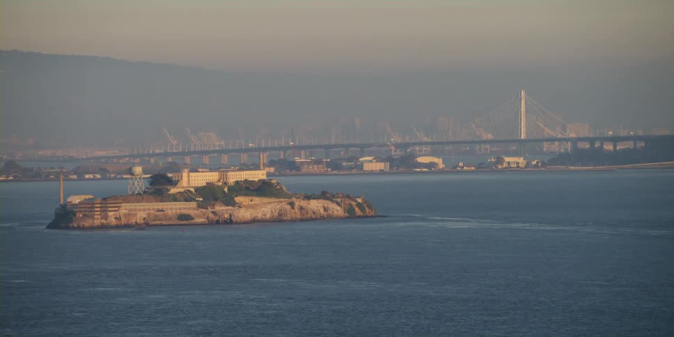 Alcatraz island in front of the san francisco oakland bay bridge